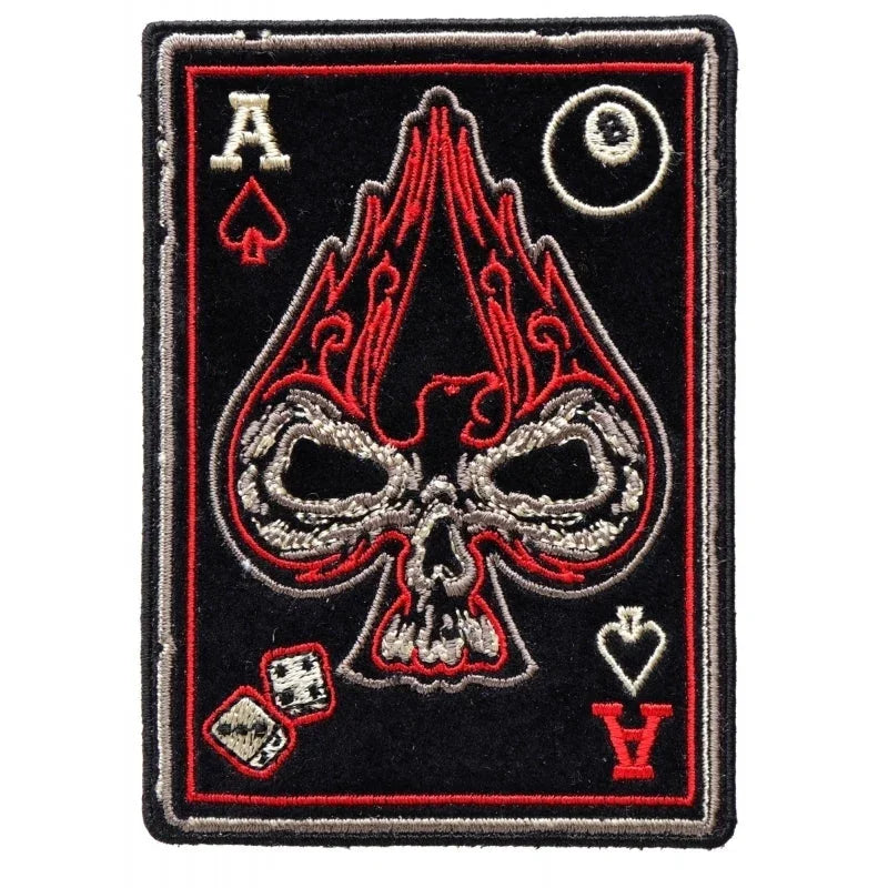 Embroidered patch with skull and playing card symbols on a black background